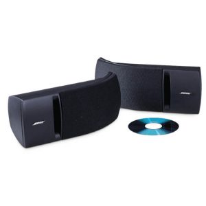 Two black Bose 161 speakers are positioned next to a compact disc on a white background.