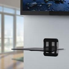 The AVF ZMS1100 Unimax Any Wall TV & AV Accessory Shelving is mounted below a flat-screen TV in a bright, modern room with large windows.