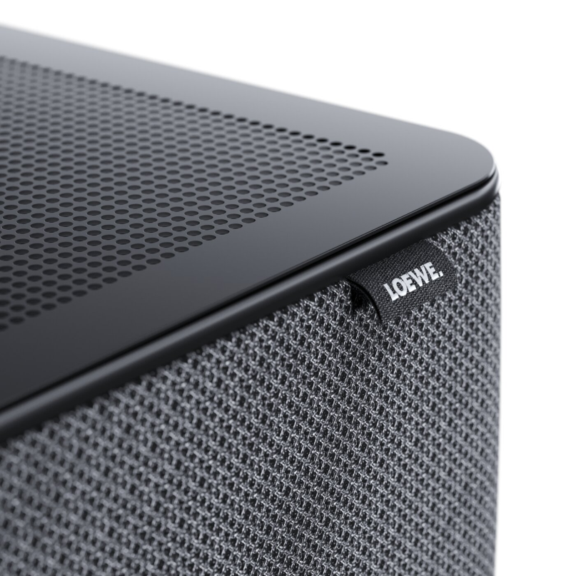 Loewe Klang Bar5 Mr &Amp; Sub5 Soundbar And Subwoofer Loewe klang bar5 mr soundbar and sub5 subwoofer shown in close-up, highlighting the black perforated top panel, fabric grille, and loewe branding.
