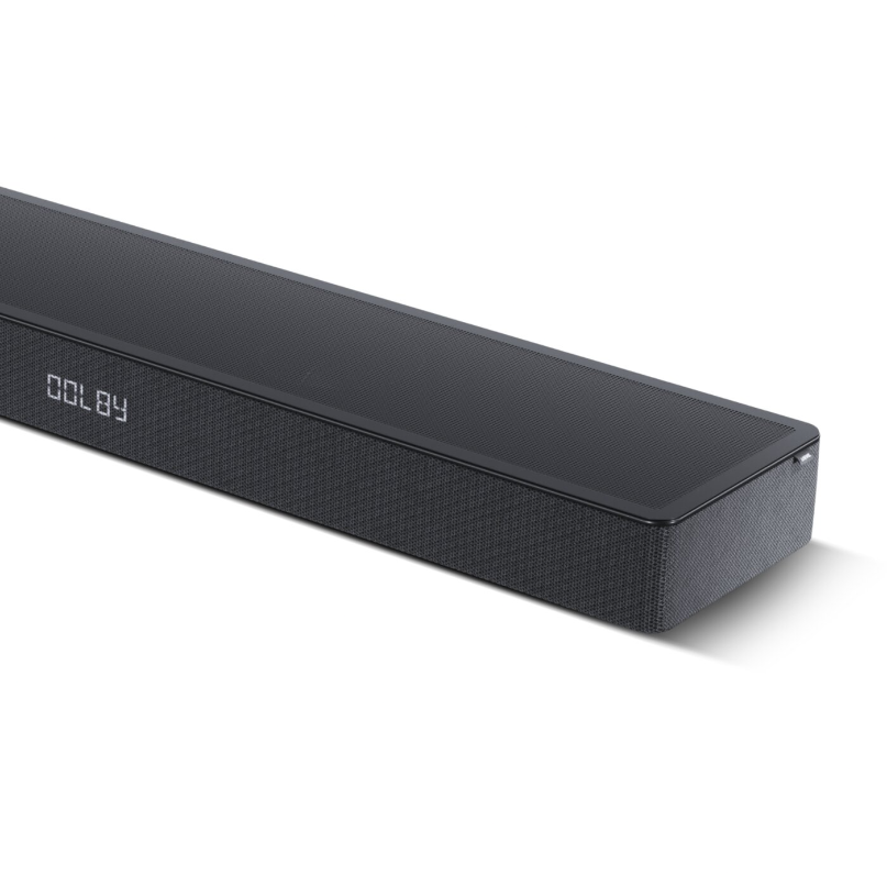 Loewe Klang Bar5 Mr &Amp; Sub5 Soundbar And Subwoofer Close-up angled view of the loewe klang bar5 mr soundbar showing its black top panel, fabric grille, and dolby display.