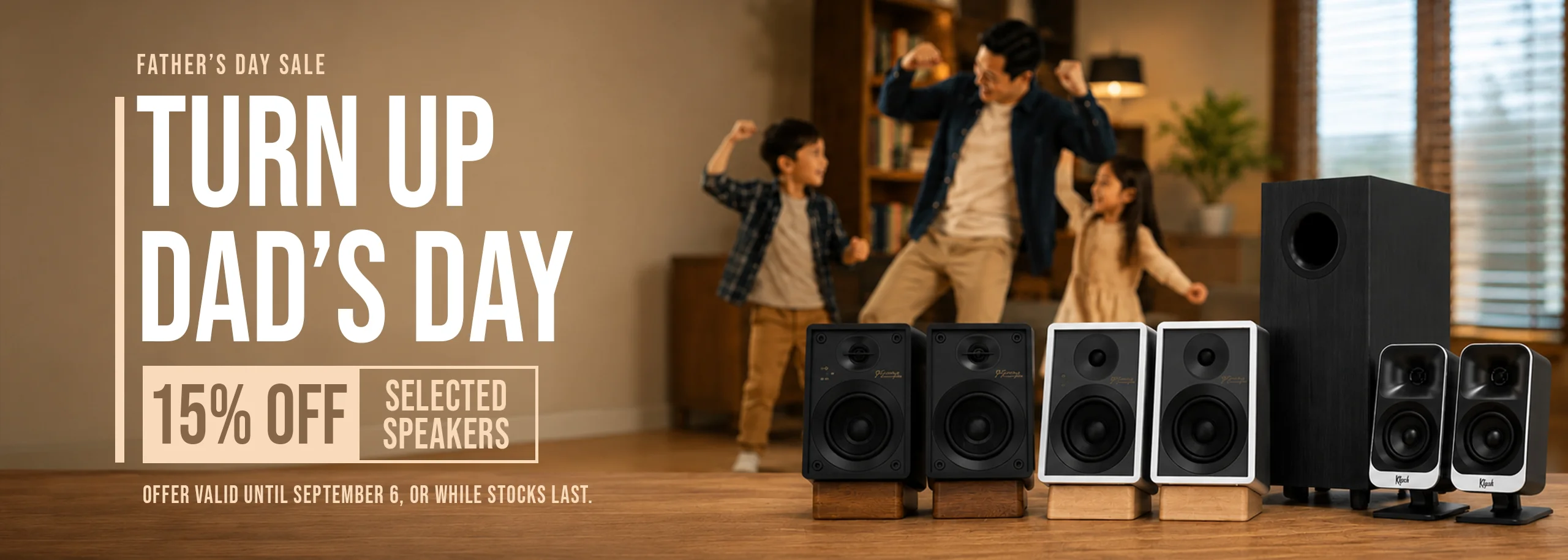 A family dances in a living room behind a display of various speakers, with text promoting a father’s day sale offering 15% off selected speakers.
